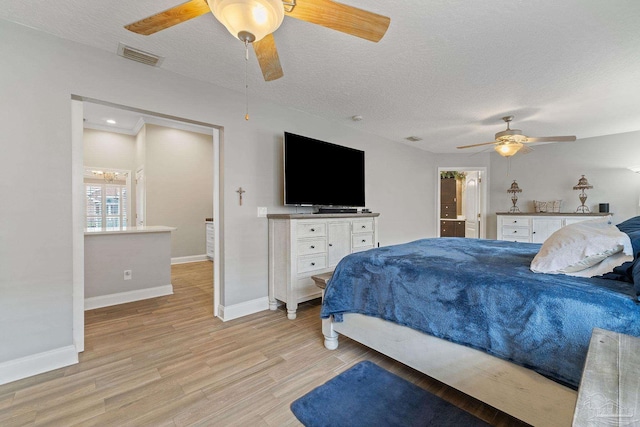 bedroom with a textured ceiling, light hardwood / wood-style floors, and ceiling fan