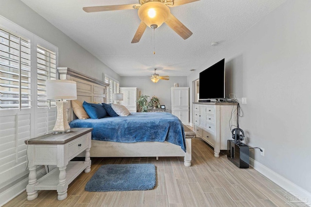 bedroom featuring a textured ceiling, light hardwood / wood-style flooring, and ceiling fan