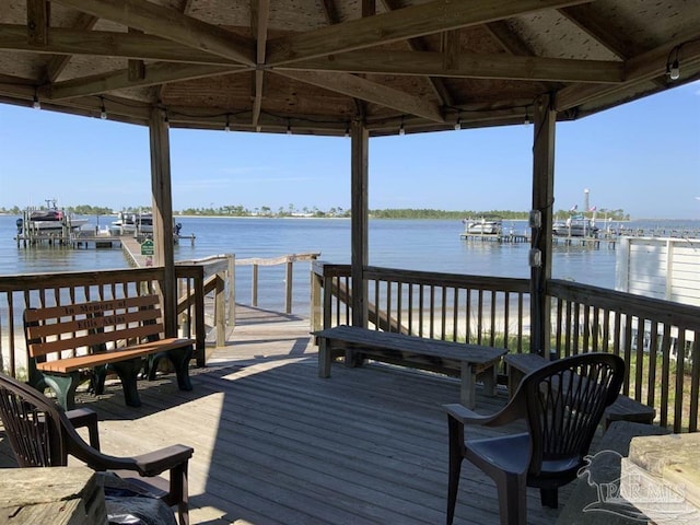 view of dock with a deck with water view and a gazebo