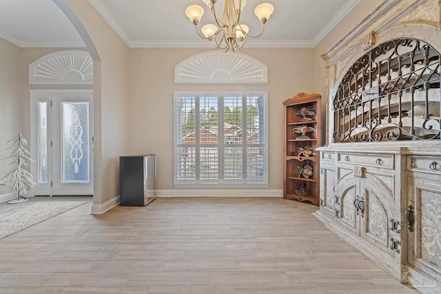 interior space featuring ornamental molding, light hardwood / wood-style floors, and a chandelier