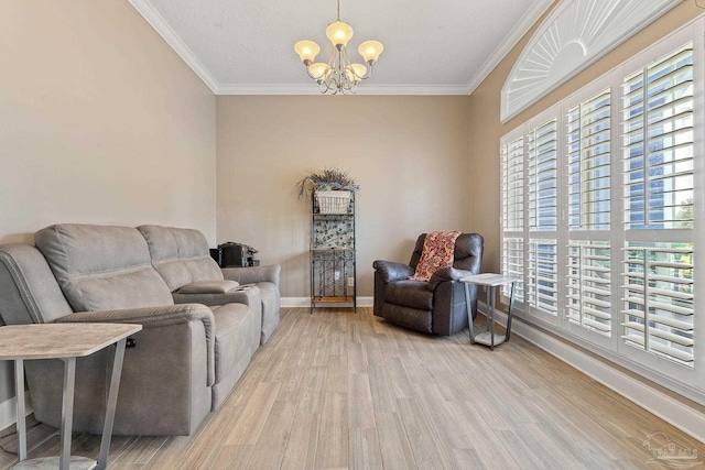 living room with light hardwood / wood-style flooring, an inviting chandelier, crown molding, and plenty of natural light