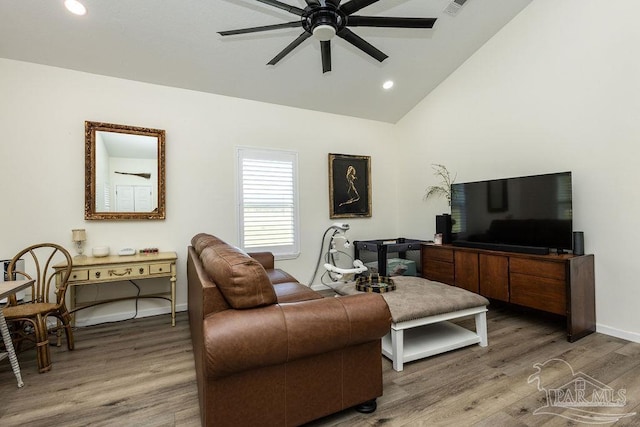 living room featuring baseboards, ceiling fan, wood finished floors, and vaulted ceiling