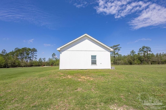 view of side of home with a lawn and an outbuilding
