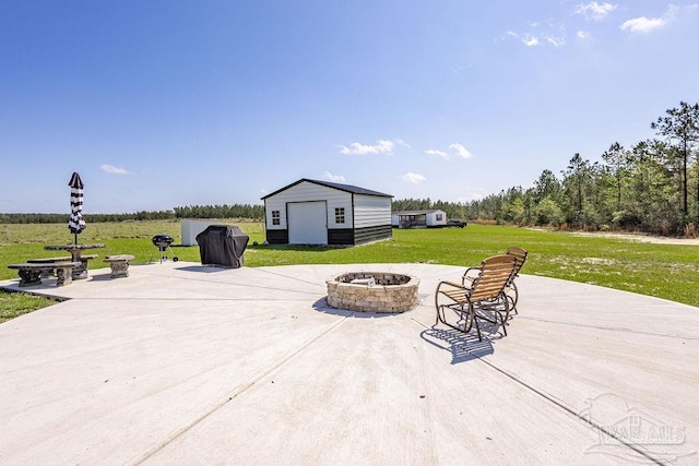 view of patio with an outdoor fire pit, an outbuilding, and a detached garage