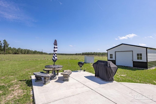 view of patio with grilling area, an outbuilding, and a garage