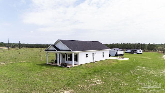 rear view of property with a lawn and a shingled roof