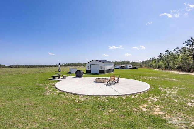 view of yard with a patio area, an outdoor fire pit, and an outdoor structure