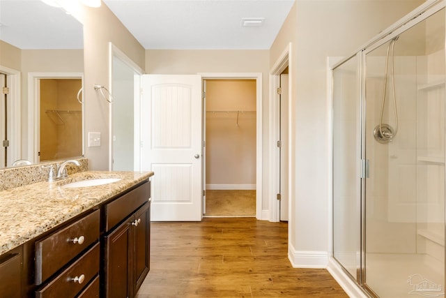 8626 Bucklebury Dr, Pensacola, FL 32507 - bathroom with a walk in closet, a shower stall, wood finished floors, and vanity