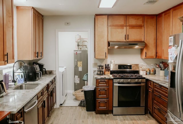 3125 Zepp Ln, Pace, FL 32571 - kitchen featuring appliances with stainless steel finishes, under cabinet range hood, electric water heater, washing machine and dryer, and light stone counters