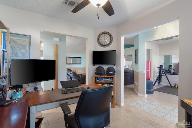 tiled home office featuring a textured ceiling and ceiling fan