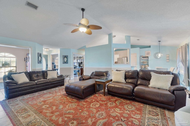 living room featuring hardwood / wood-style floors, a textured ceiling, vaulted ceiling, and ceiling fan