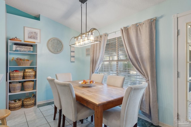 dining area featuring light tile patterned floors and a textured ceiling