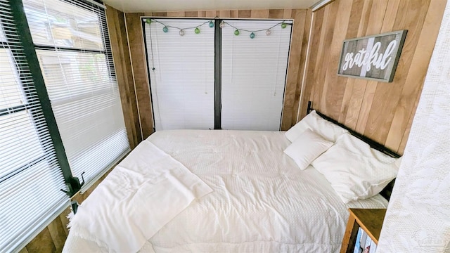 bedroom featuring wooden walls and a closet