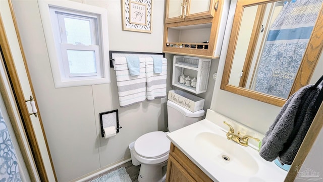 bathroom featuring toilet, curtained shower, and vanity