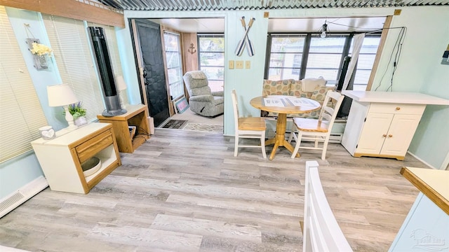 dining room featuring a baseboard heating unit and light hardwood / wood-style flooring