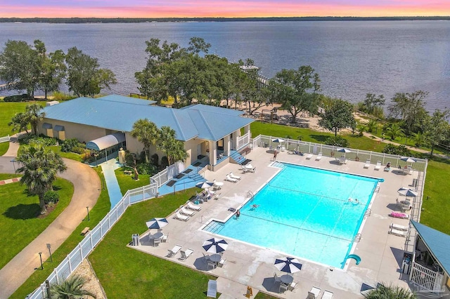 aerial view at dusk featuring a water view