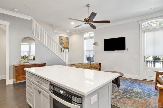 kitchen featuring plenty of natural light, a center island, dark wood finished floors, and crown molding