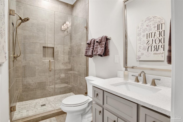 bathroom featuring a stall shower, toilet, and vanity