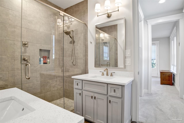 full bath featuring a stall shower, vanity, and baseboards