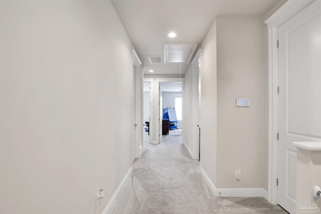 hallway featuring visible vents, baseboards, light colored carpet, attic access, and recessed lighting