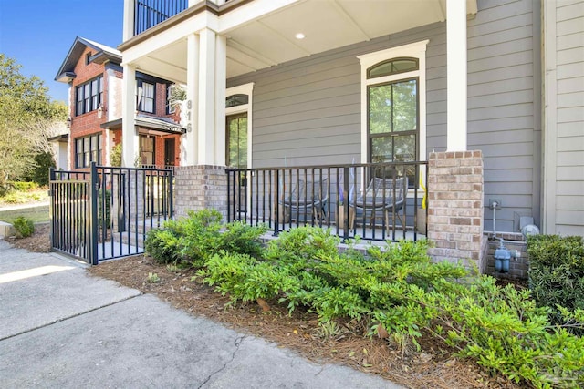 doorway to property featuring brick siding and covered porch