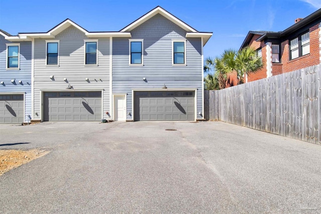 exterior space with an attached garage and fence