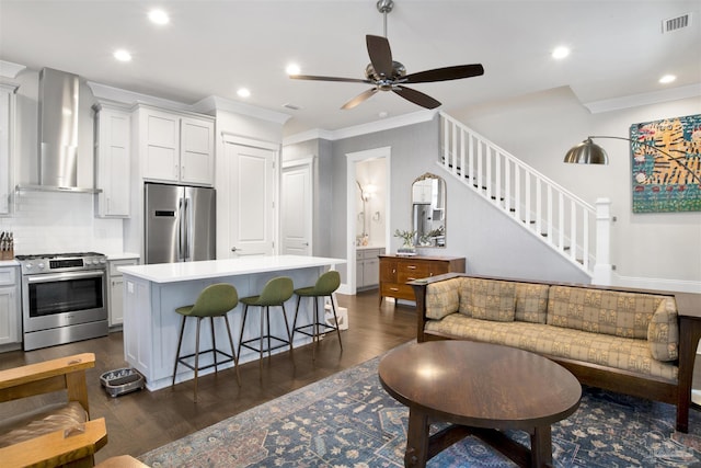 living room featuring stairs, visible vents, dark wood-style flooring, and ornamental molding