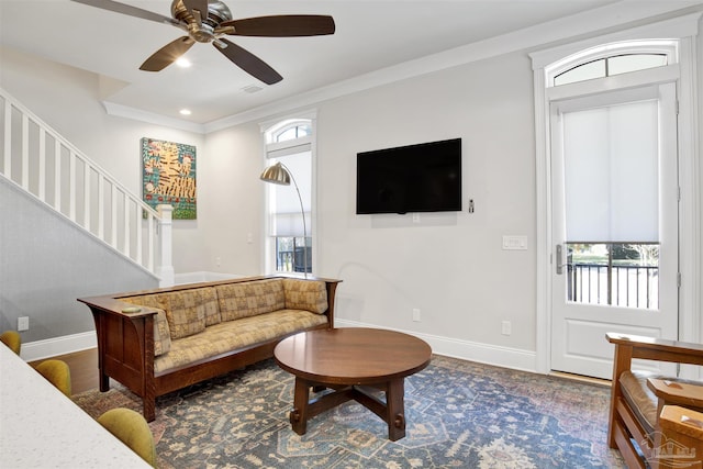 living area featuring wood finished floors, baseboards, recessed lighting, stairs, and crown molding