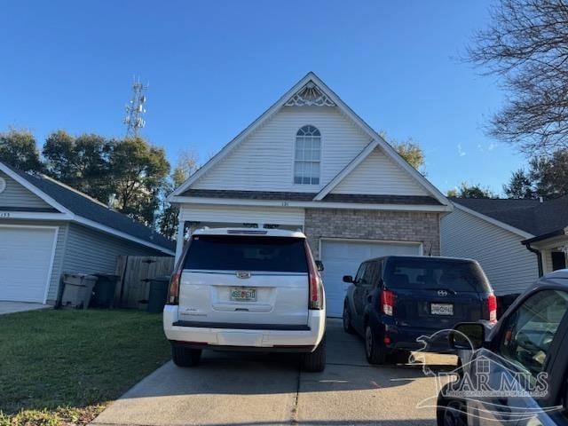 view of front of home featuring brick siding, driveway, a front yard, and a garage