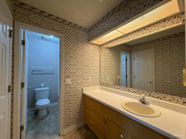 bathroom with toilet, tile patterned flooring, and vanity