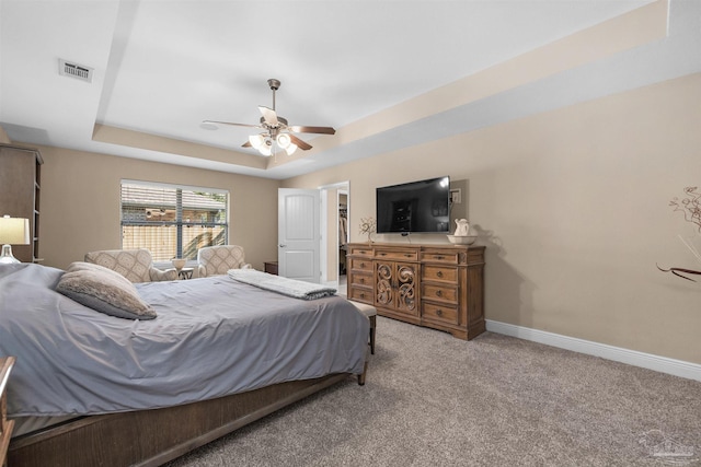 bedroom with carpet flooring, a tray ceiling, and ceiling fan