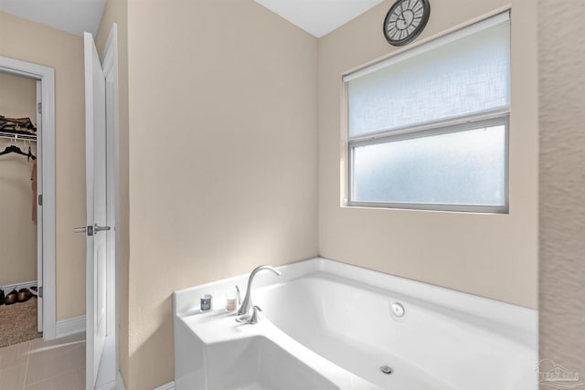 bathroom with a tub to relax in and tile patterned flooring