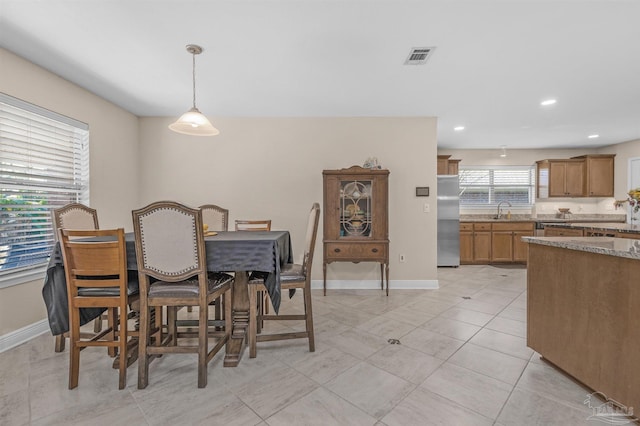 tiled dining room featuring sink