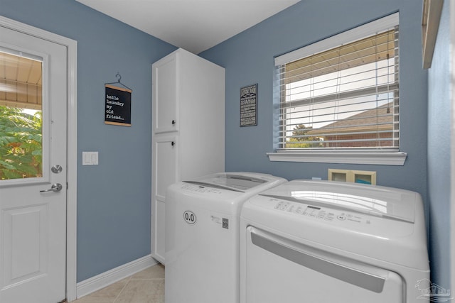 washroom featuring cabinets, washer and dryer, and light tile patterned flooring