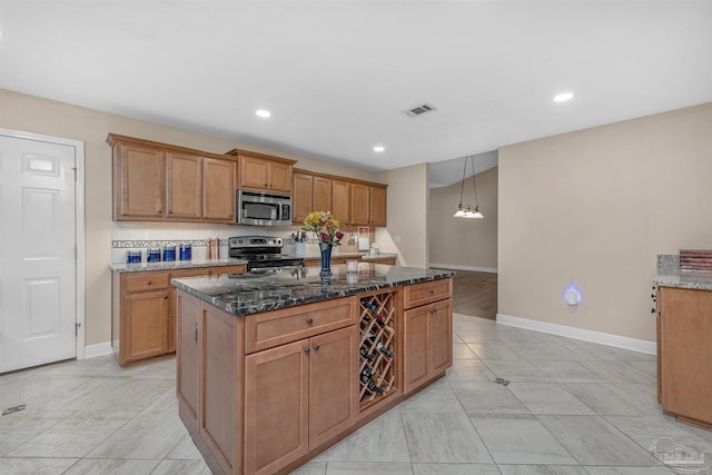 kitchen with a kitchen island, appliances with stainless steel finishes, backsplash, and dark stone counters