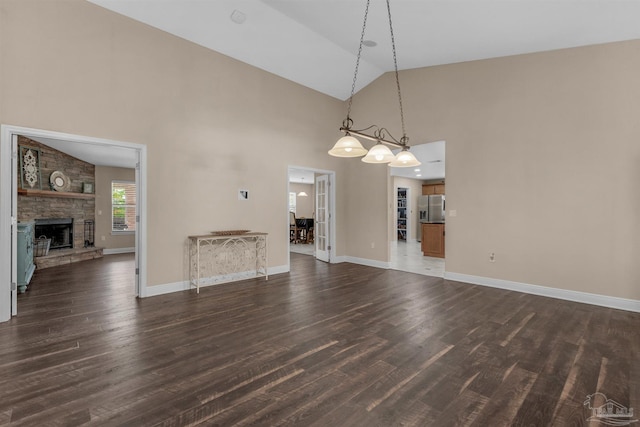 unfurnished living room featuring a fireplace, dark hardwood / wood-style floors, and high vaulted ceiling