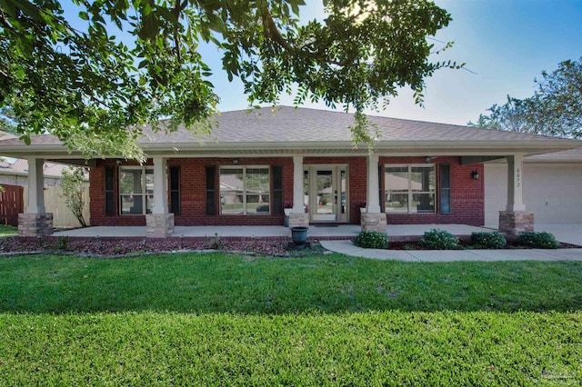 ranch-style house with a front yard, covered porch, and a garage