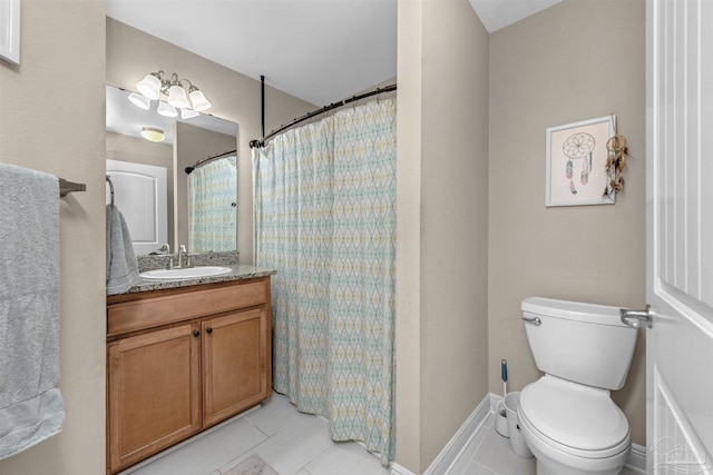 bathroom with toilet, vanity, and tile patterned flooring