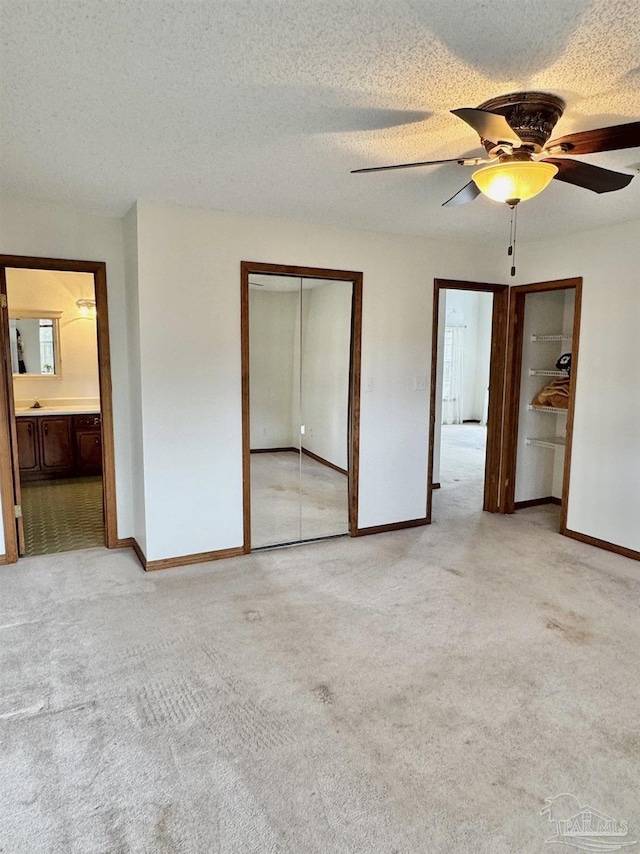 unfurnished bedroom with light carpet, ceiling fan, a closet, and a textured ceiling