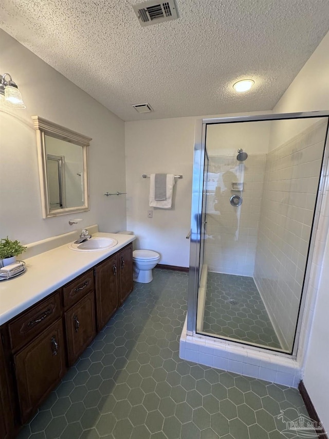 bathroom featuring tile patterned flooring, vanity, an enclosed shower, toilet, and a textured ceiling