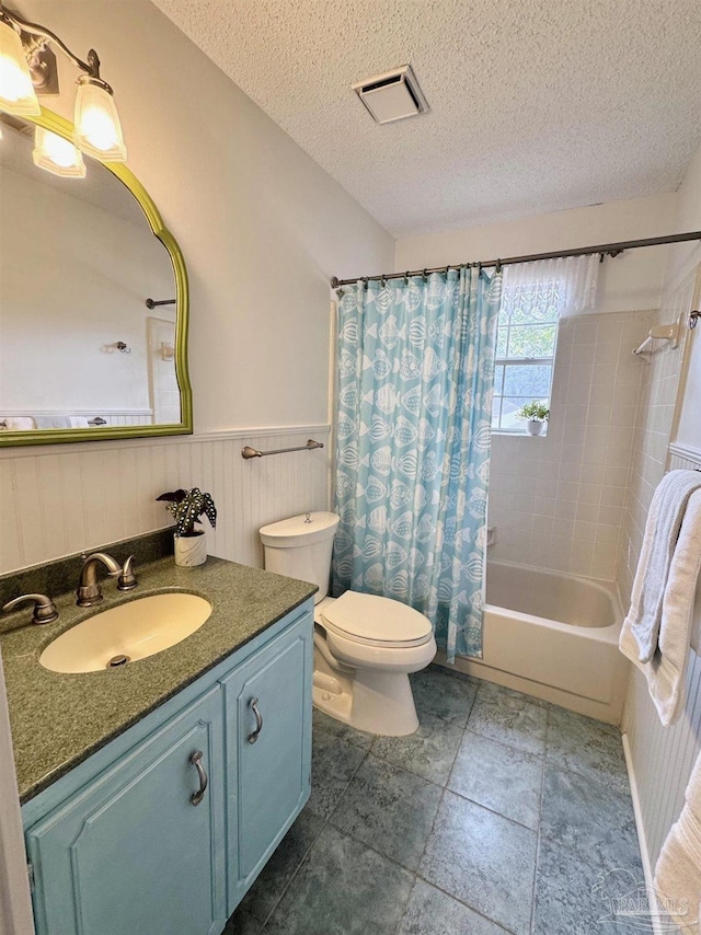 full bathroom featuring vanity, toilet, shower / bath combination with curtain, and a textured ceiling