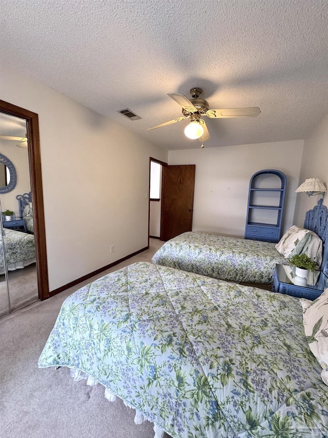 carpeted bedroom featuring a textured ceiling, a closet, and ceiling fan