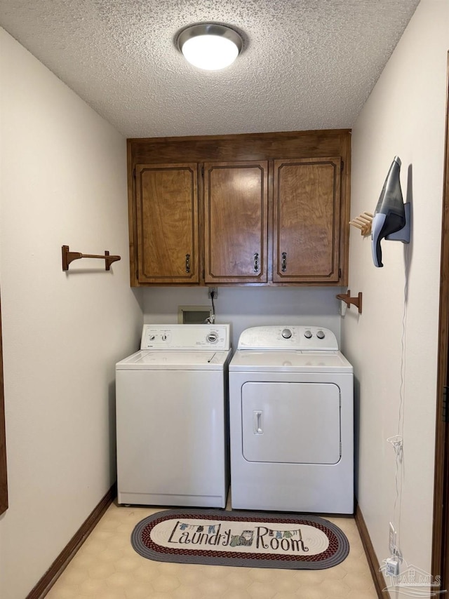 washroom featuring independent washer and dryer, cabinets, and a textured ceiling