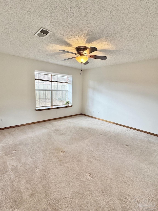 carpeted empty room with ceiling fan and a textured ceiling