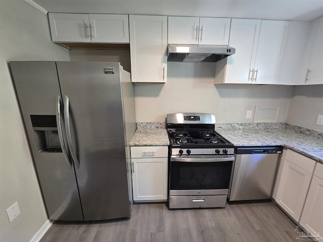 kitchen with under cabinet range hood, stainless steel appliances, white cabinets, and light wood-type flooring