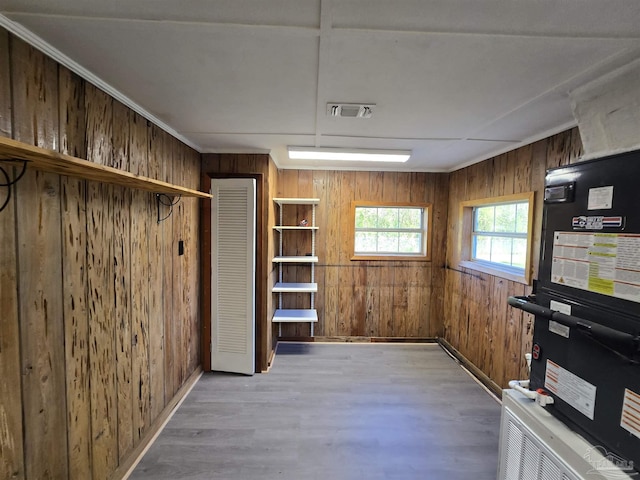 basement with visible vents, wood walls, and wood finished floors