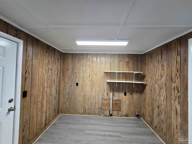 clothes washing area with wooden walls and wood finished floors