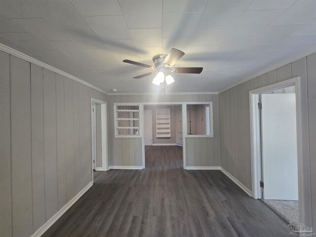 unfurnished room featuring baseboards, ornamental molding, a ceiling fan, and dark wood-type flooring
