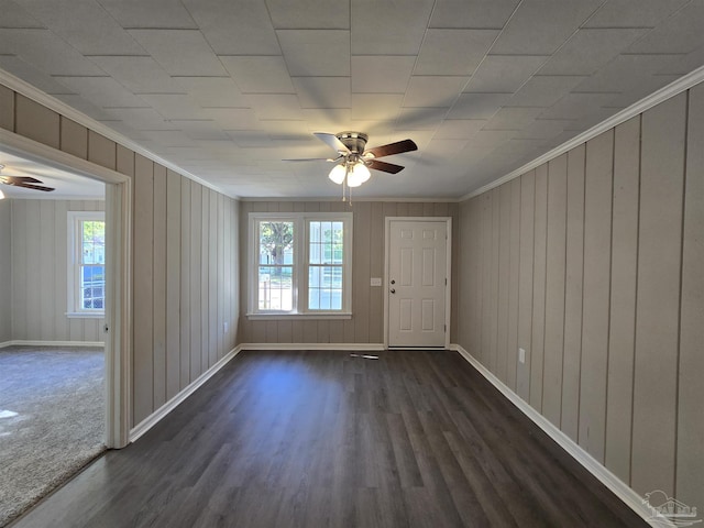unfurnished room featuring ceiling fan, ornamental molding, baseboards, and dark wood-type flooring