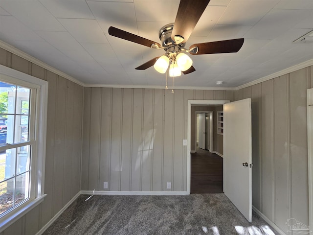 unfurnished bedroom with carpet flooring, crown molding, and wood walls